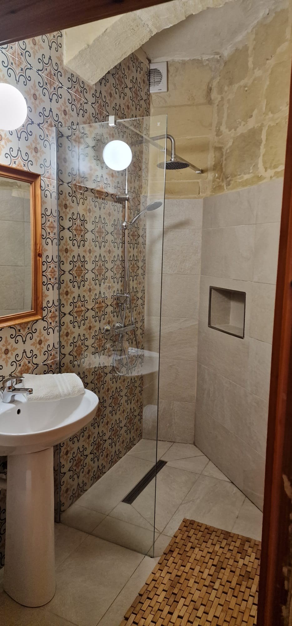 Ensuite shower room with patterned tiles at Molendini Farmhouse