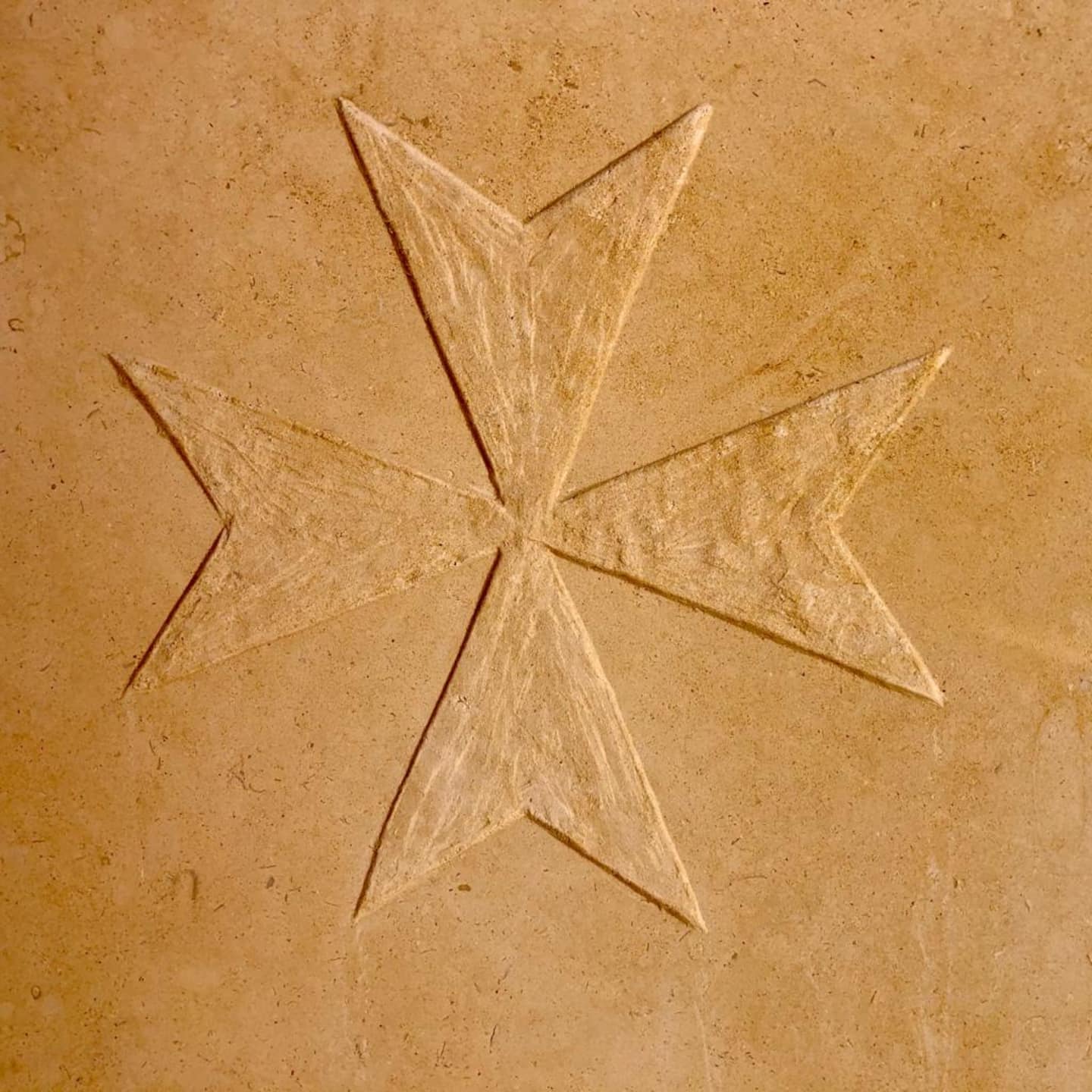 A carved Maltese cross in the farmhouse stone