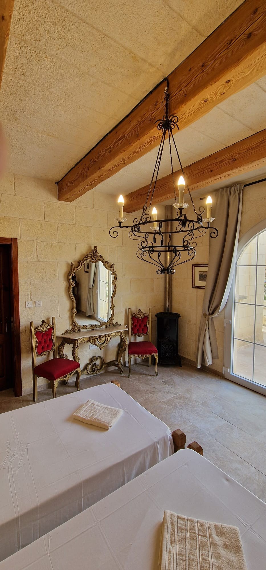 Bedroom with twin beds, exposed timber beams and a chandelier